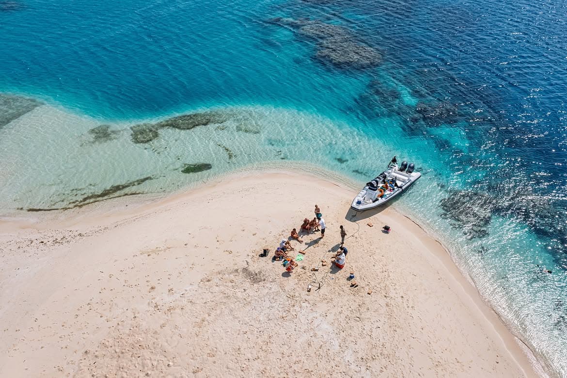 Aerial beach and boat view above turquoise kite waters