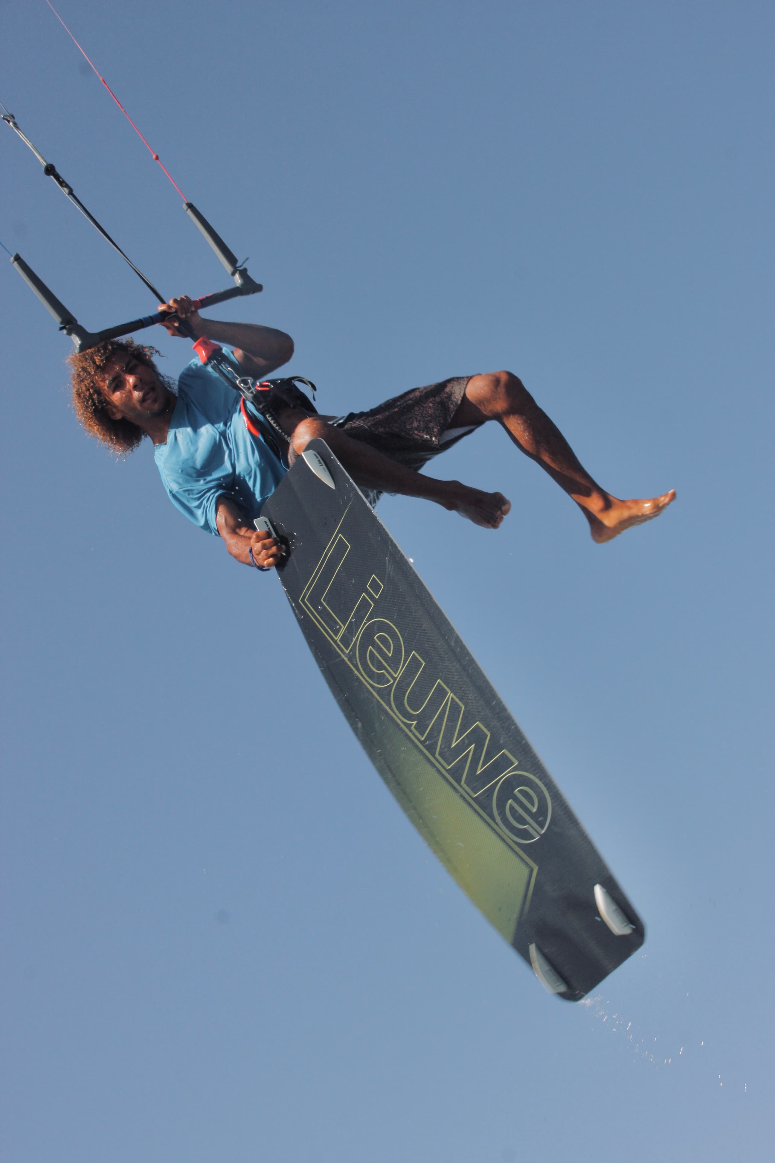 Anubis Kite rider inverted mid-air with the board held overhead