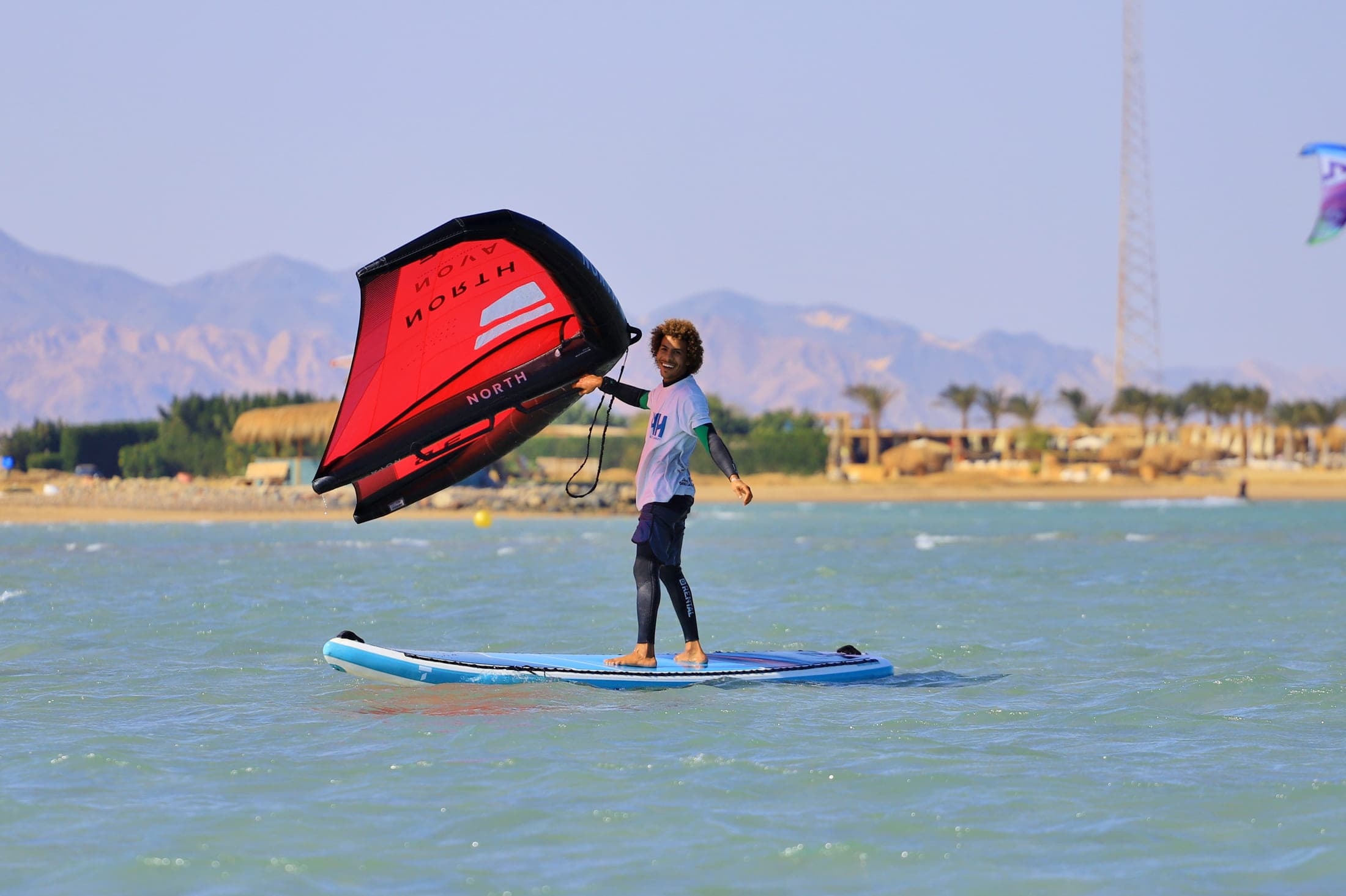 Rider on the water with the El Gouna shoreline and the Red Sea mountains behind
