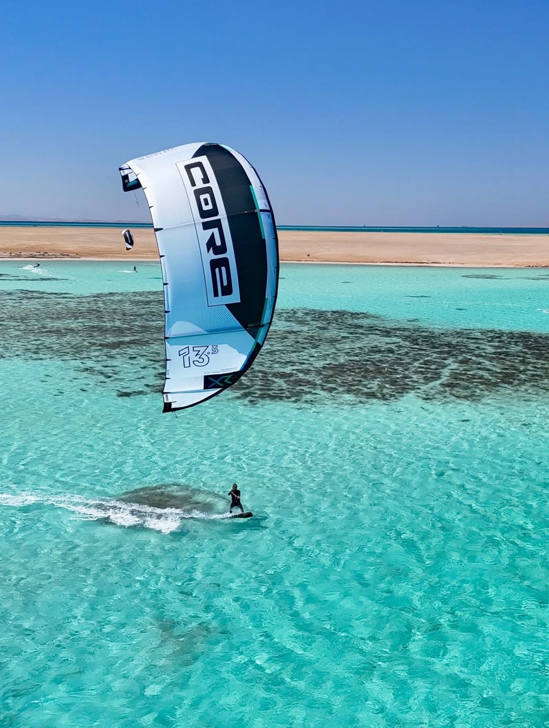 Kite flying above the shallow turquoise flats of the Red Sea, seen from the air